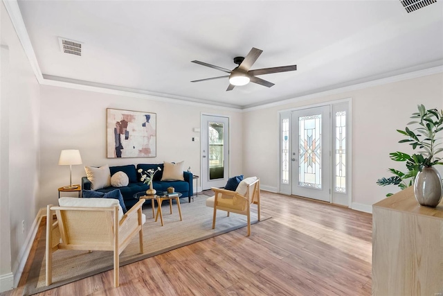 sitting room with visible vents, baseboards, ornamental molding, and light wood finished floors