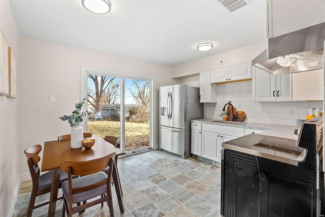 kitchen with ventilation hood, visible vents, a sink, stainless steel refrigerator with ice dispenser, and backsplash