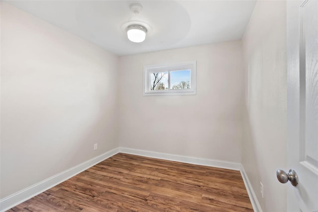 empty room with dark wood finished floors and baseboards