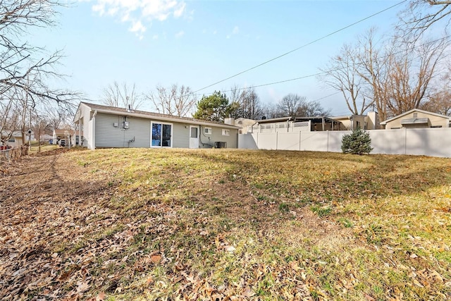 back of house featuring a yard, central AC, and fence