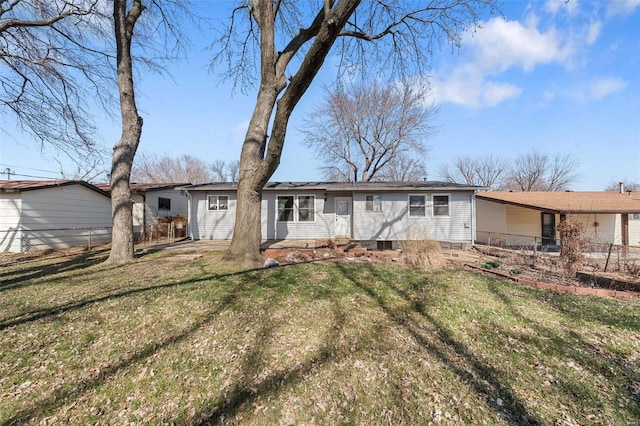 back of property with entry steps, a yard, and fence