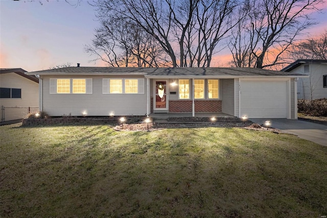 ranch-style home featuring a yard, concrete driveway, and an attached garage