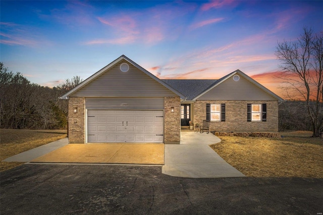 single story home with brick siding, an attached garage, and concrete driveway