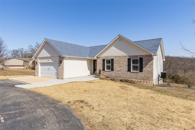 ranch-style house featuring a garage, brick siding, driveway, and a shingled roof