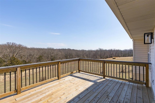 wooden terrace featuring a wooded view