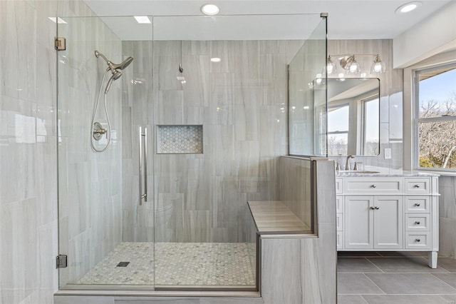 bathroom with tile patterned floors, a shower stall, and vanity