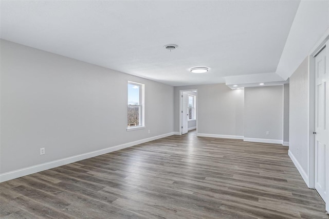 unfurnished room with visible vents, baseboards, and wood finished floors