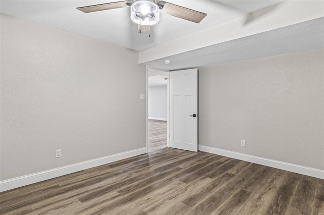 empty room featuring a ceiling fan, baseboards, and wood finished floors