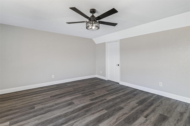 unfurnished room with baseboards, a ceiling fan, lofted ceiling, and dark wood-style flooring