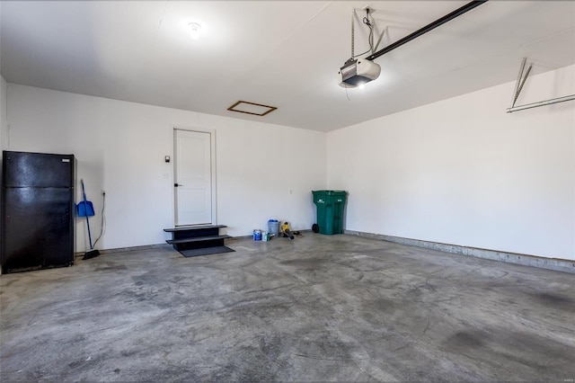 garage featuring baseboards, a garage door opener, and freestanding refrigerator