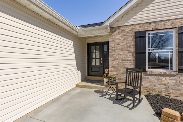 view of exterior entry featuring brick siding