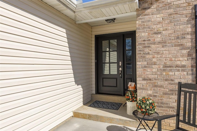 doorway to property featuring brick siding