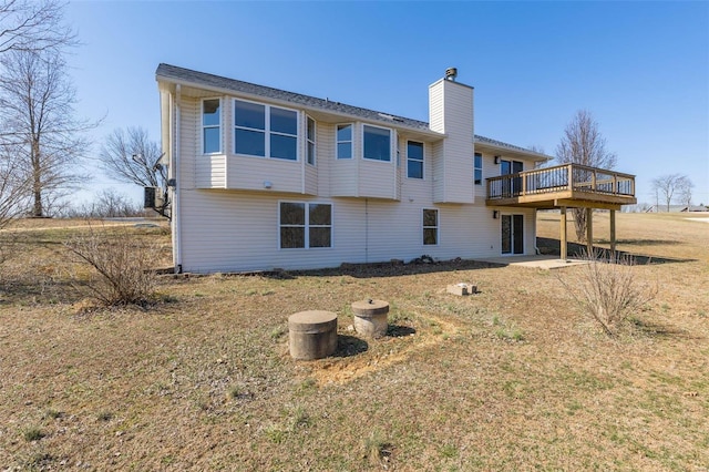 rear view of house with a wooden deck and a chimney