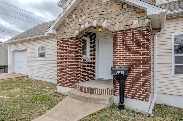 view of exterior entry featuring stone siding, an attached garage, brick siding, and roof with shingles