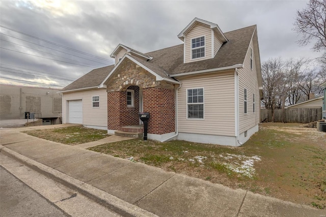 view of front facade featuring a garage, stone siding, brick siding, and fence