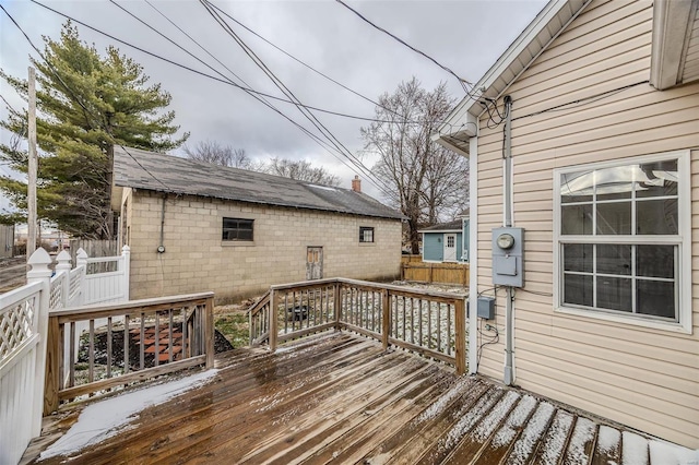 wooden deck featuring an outbuilding and fence