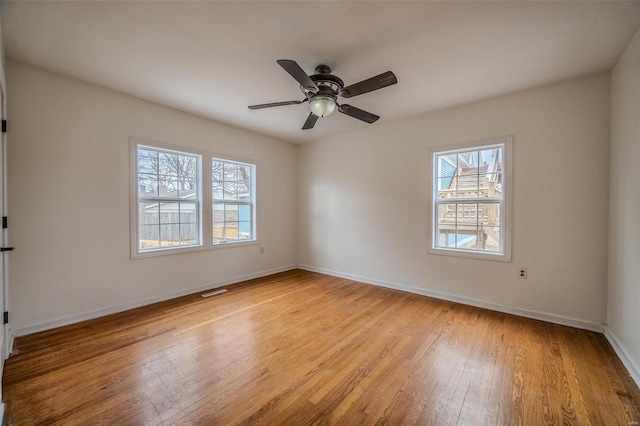 empty room with visible vents, baseboards, ceiling fan, and light wood finished floors