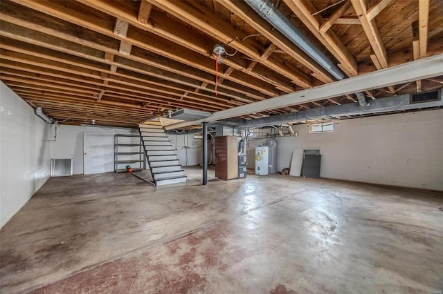 below grade area with stairway, heating unit, and electric water heater