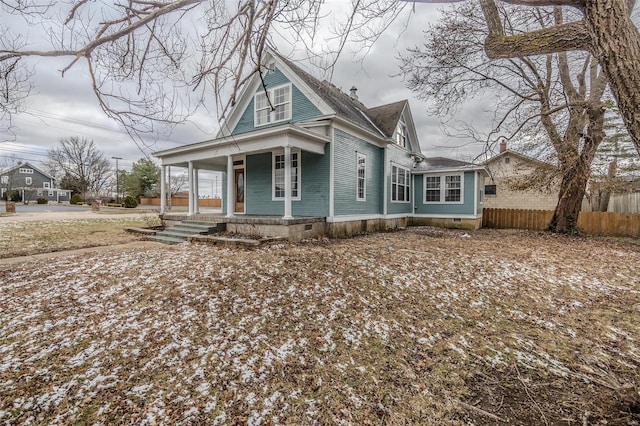 view of front of house with crawl space, covered porch, and fence