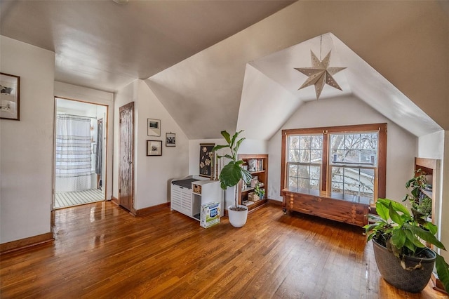 bonus room featuring hardwood / wood-style floors, lofted ceiling, and baseboards