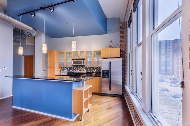 kitchen featuring open shelves, appliances with stainless steel finishes, dark countertops, light wood-type flooring, and backsplash