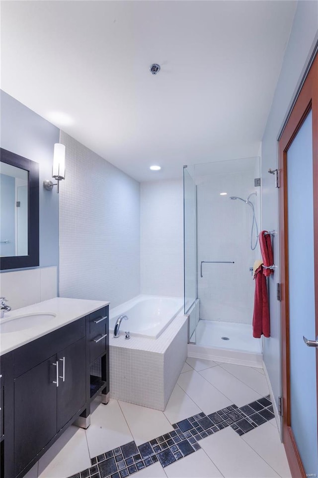 bathroom featuring a garden tub, a shower stall, vanity, and tile patterned flooring