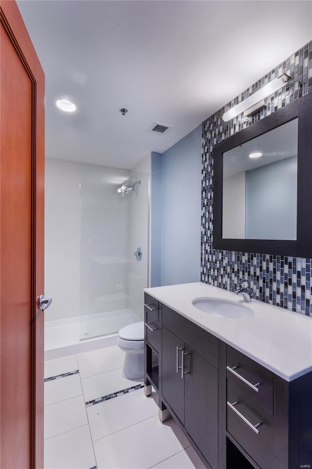 full bathroom featuring vanity, visible vents, a stall shower, tile patterned floors, and backsplash