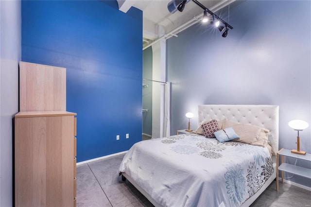 bedroom featuring track lighting and baseboards