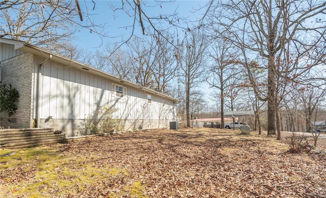 view of side of property with cooling unit and brick siding