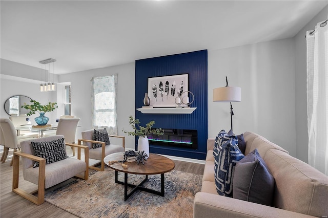 living room with a glass covered fireplace and wood finished floors