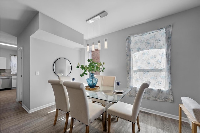 dining area with baseboards and wood finished floors