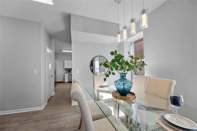 dining space with baseboards and wood finished floors