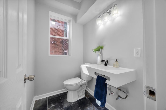 bathroom featuring tile patterned floors, toilet, and baseboards