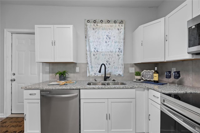 kitchen with white cabinets, appliances with stainless steel finishes, and a sink