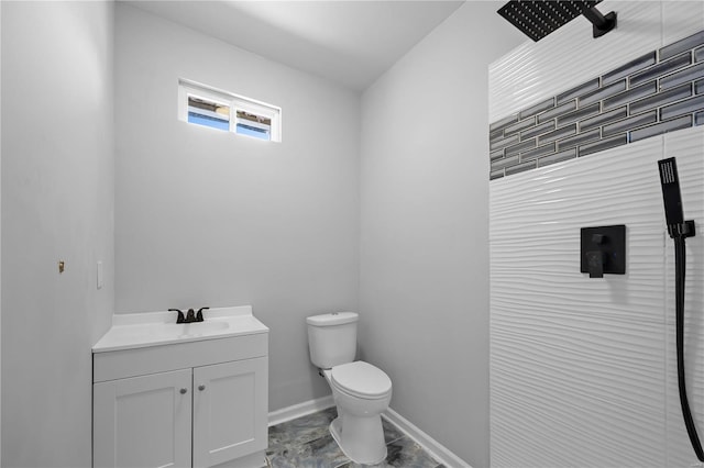 bathroom featuring toilet, vanity, and baseboards