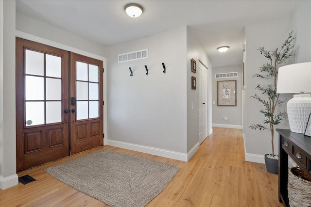 entryway with visible vents, french doors, and light wood-type flooring