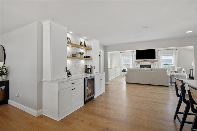 kitchen featuring light countertops, beverage cooler, and light wood finished floors