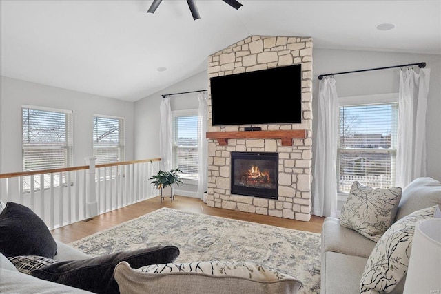 living room with a fireplace, lofted ceiling, a ceiling fan, and wood finished floors