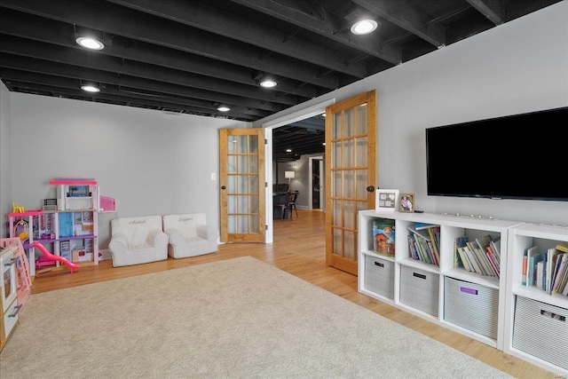 game room featuring wood finished floors, french doors, and beam ceiling