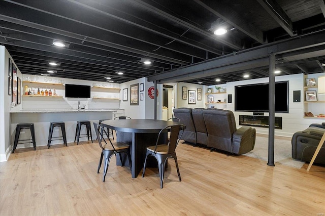 dining space featuring wet bar and light wood-style floors