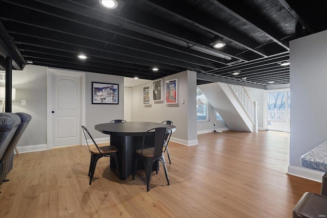 dining room featuring stairway, baseboards, and light wood-type flooring