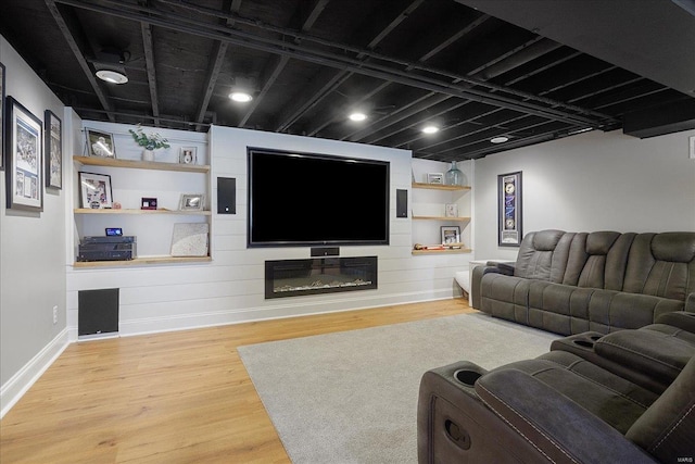 living area featuring a fireplace, baseboards, and wood finished floors