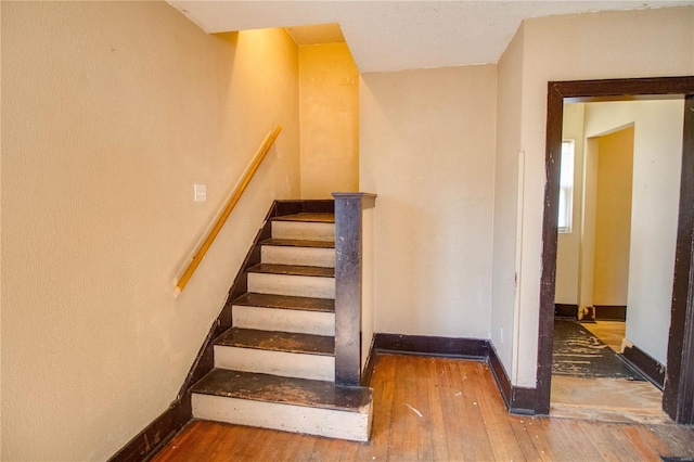 stairs with hardwood / wood-style flooring and baseboards