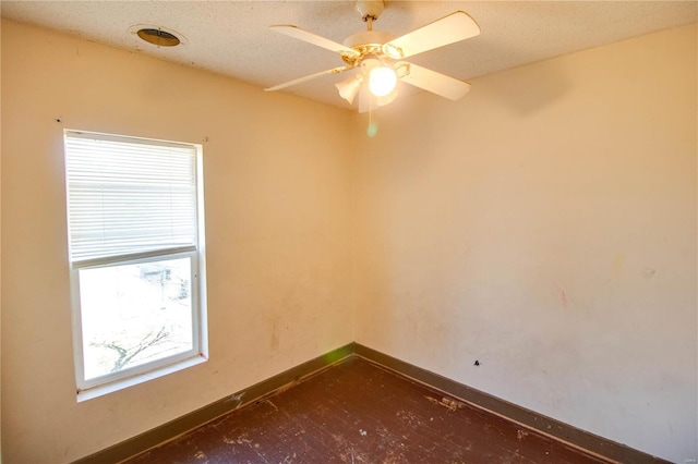 spare room featuring a ceiling fan, baseboards, and a textured ceiling