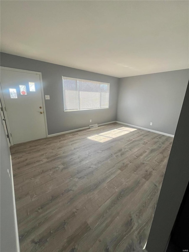 interior space with visible vents, baseboards, and wood finished floors