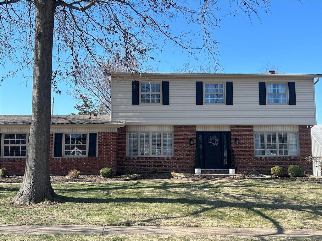 view of front facade featuring brick siding and a front lawn