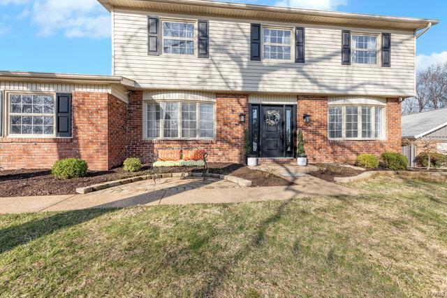 colonial house with brick siding and a front yard