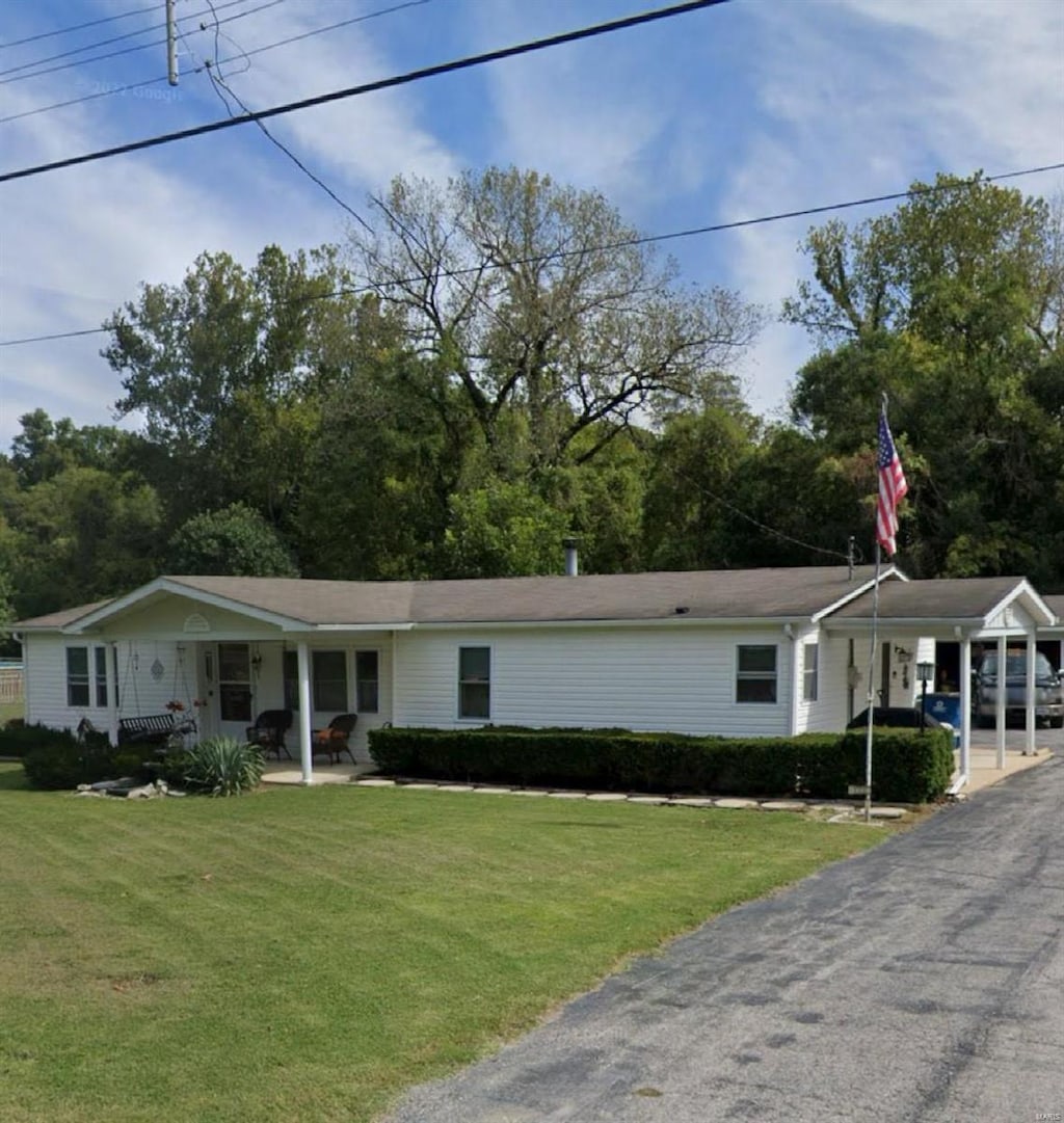 view of front of property with an attached carport and a front yard