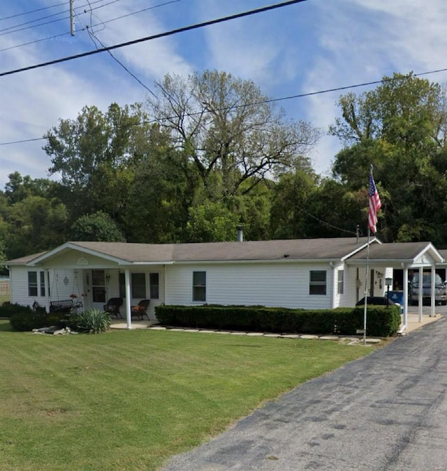 view of front of property with an attached carport and a front yard