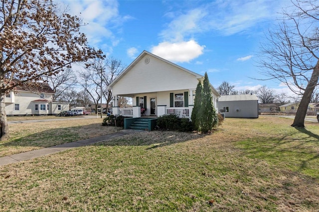 bungalow with a front yard and covered porch